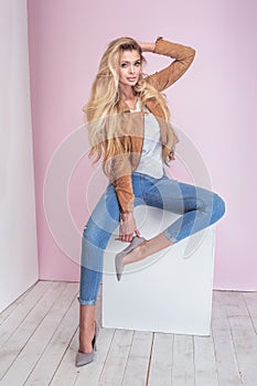 Fashionable blonde woman on pink background.