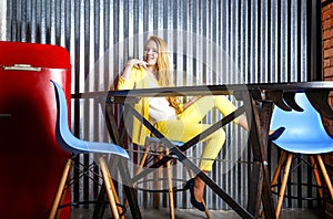 Fashionable blonde woman portrait in retro cafe, garage or office