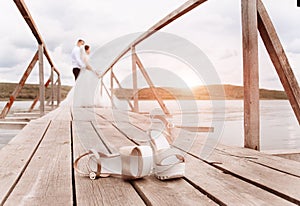 Fashionable bride shoes on the dock. Silhouette of the bride and