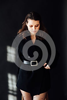 fashionable brunette woman posing on a black background