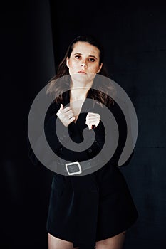 fashionable brunette woman posing on a black background