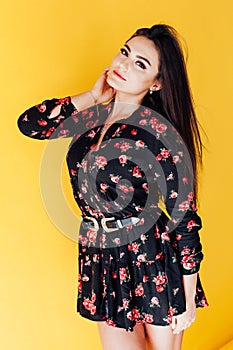 fashionable brunette woman posing on a yellow background