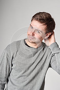 Fashionable casual happy young man with light beard, on gray background