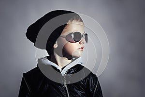 Fashionable child boy in sunglasses. Kid in Black cap. Autumn style. Winter.Little boy