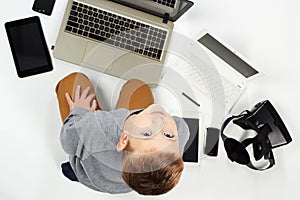 Fashionable child with computers, tablets, phones, gadgets around