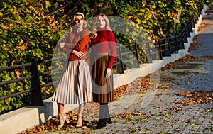 Fashionable clothes. Femininity and tenderness. Friends girls. Fall fashion. Pleated skirt fashion trend. Women walking