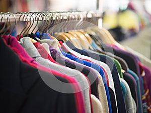 Fashionable clothes on hangers in a store photo
