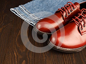 Fashionable concept. casual wear, yellow work boots from natural leather, blue jeans on black background. Trendy casual