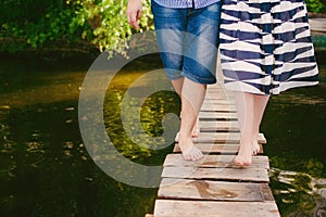 Fashionable cool couple on a bridge near the water, relationships, romance, legs, lifestyle - concept