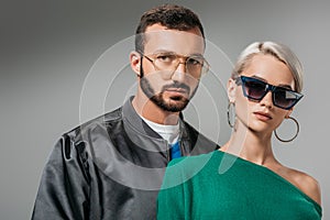 fashionable couple posing in eyeglasses and sunglasses