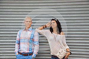 Fashionable couple posing in front of a metal door
