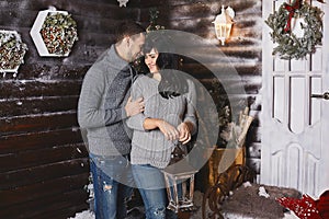 Fashionable couple, stylish handsome men hugs the beautiful brunette model girl in a trendy grey sweatshirt and posing