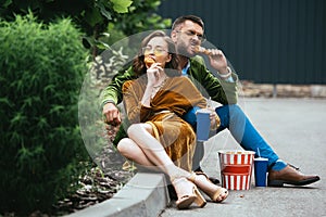 fashionable couple in velvet clothing eating fried chicken legs photo