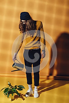 fashionable elegant man watering houseplant