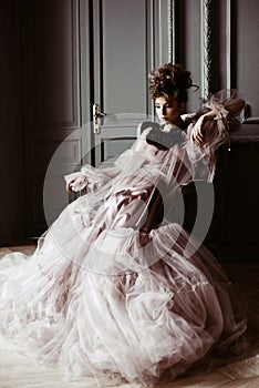 Fashionable female portrait of cute lady in pink dress indoors