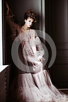 Fashionable female portrait of cute lady in pink dress indoors