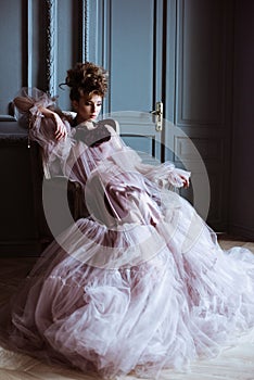 Fashionable female portrait of cute lady in pink dress indoors