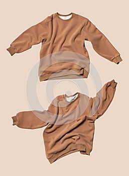 Fashionable flying brown cotton stylish sweatshirt isolated on beige background. Clothes, fashion, clean sweatshirt jacket