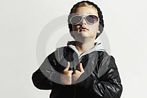 Fashionable funny child in sunglasses. Black cap.winter style.Posing Little boy.Children fashion. Kids