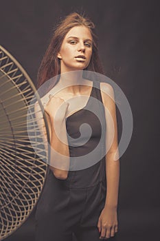 Fashionable girl in golden gray tones in studio. Woman with unflappable face. Lifestyle concept in fashion world