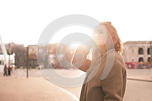 Fashionable girl posing on the camera at the background of the sunset, wearing a stylish casual clothing. Young lady in the spring