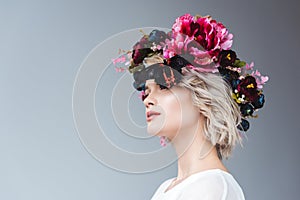 fashionable girl posing in floral wreath with butterfly