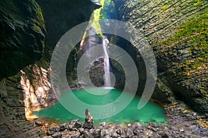 Fashionable girl in swimsuit relaxes in front of the Kozjak Waterfall, Slovenia