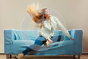 Fashionable girl wearing denim relaxing on couch.