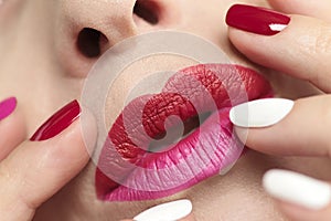 Fashionable glamorous manicure and lip makeup with red pink lipstick