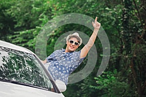 Fashionable guy enjoying road trip in nature.