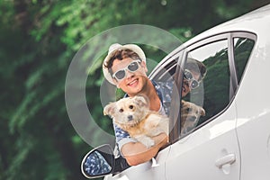 Fashionable guy with his dog out of car window.