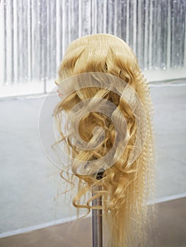 Fashionable hairstyle with curls on a mannequin.