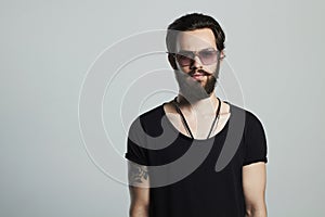 Fashionable handsome man. Brutal bearded boy in trendy glasses