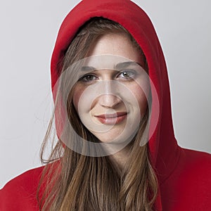 Fashionable happy 20s girl wearing a hoodie on for coolness photo