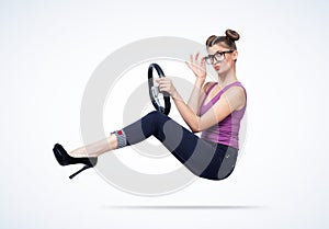 Fashionable happy young woman in glasses with car steering wheel. Girl auto driving concept