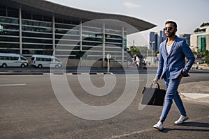 Trendy Indian businessman walking in city on daily work commute photo