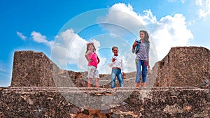 Fashionable kids with modern attitude selfie shot. Children giving shot on a ancient fort with blue sky background