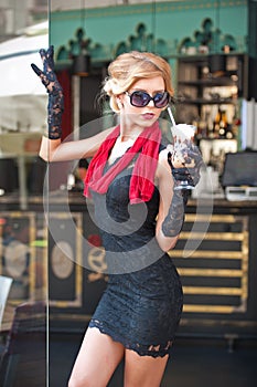 Fashionable lady with short black lace dress and red scarf and high heels, outdoor shot . Young attractive short haired blonde