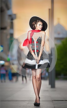 Fashionable lady wearing black hat posing on the street