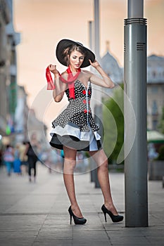 Fashionable lady wearing black hat posing on the street