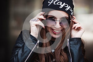 The fashionable laughing young girl in sunglasses