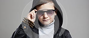 Fashionable little boy in hoodie and sunglasses