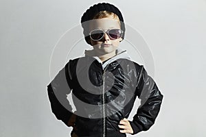 Fashionable little boy in sunglasses. Child in Black cap. Winter style.Kids fashion