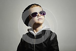 Fashionable little boy in sunglasses. Child.Posing little model in black cap