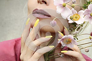 Fashionable makeup and yellow manicure .