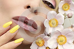 Fashionable makeup and yellow manicure .