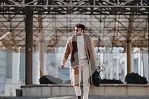 Stylish young man walking with confidence in urban setting. photo