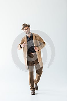 fashionable man posing in brown autumn coat and hat