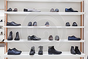 Fashionable men`s and women`s shoes on a stylish showcase in a boutique. Front view