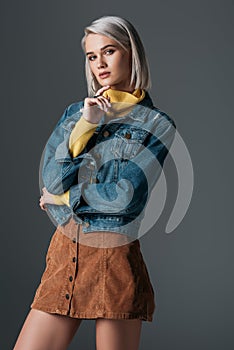 fashionable model posing in turtleneck trendy corduroy skirt and jeans jacket